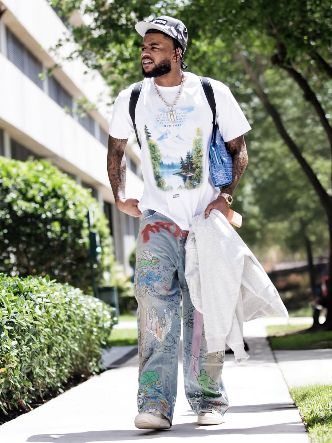 Cam Whitmore wearing Supreme Layered Camo Camp Cap ‘Snow Camo’, Kith for Bob Ross Inspiration Vintage Tee – White and ART IS WAR PAINTER.
