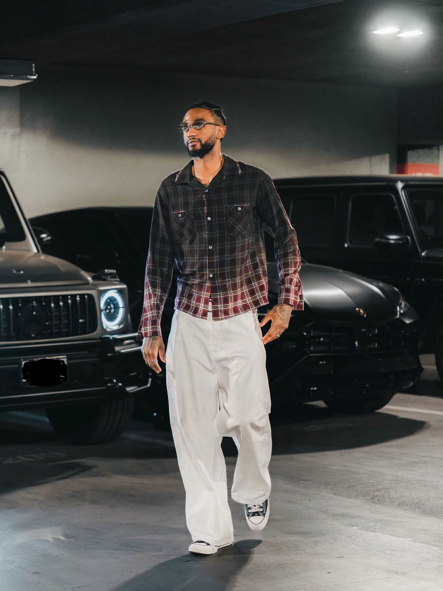 Nickeil Alexander Walker wearing Maison Margiela Gradient check shirt, Entire Studios Dem mid-rise wide-leg jeans and Converse Converse All Star ’70s.