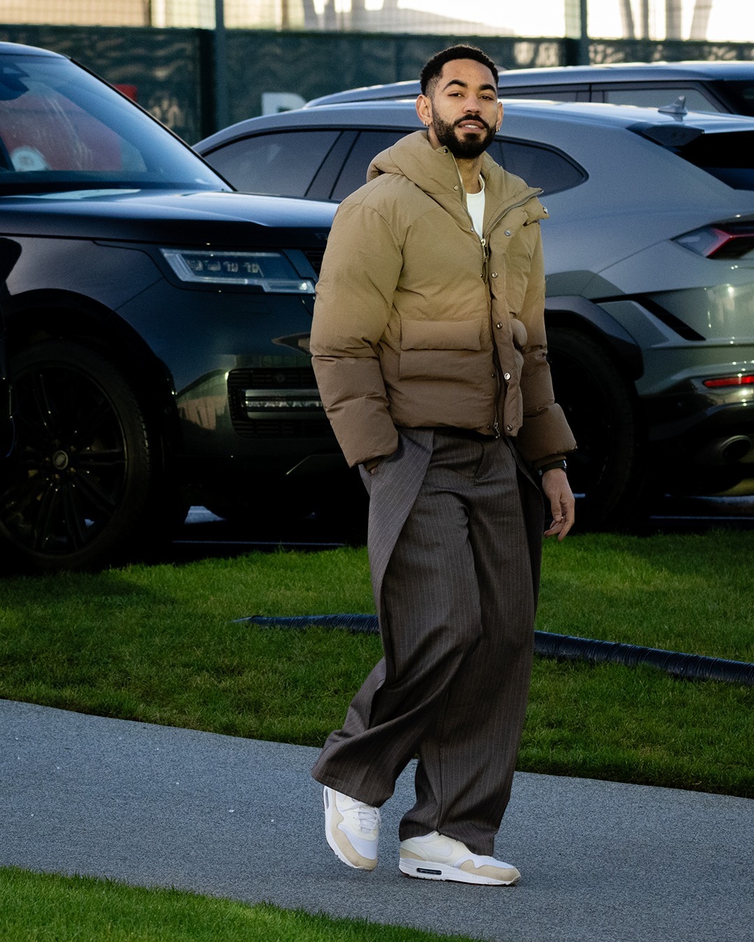 Matheus Cunha wearing Maniere De Voir Charles wide fit wrap leg pinstripe tailored trousers and Nike Air max 1 sc panelled sneakers.