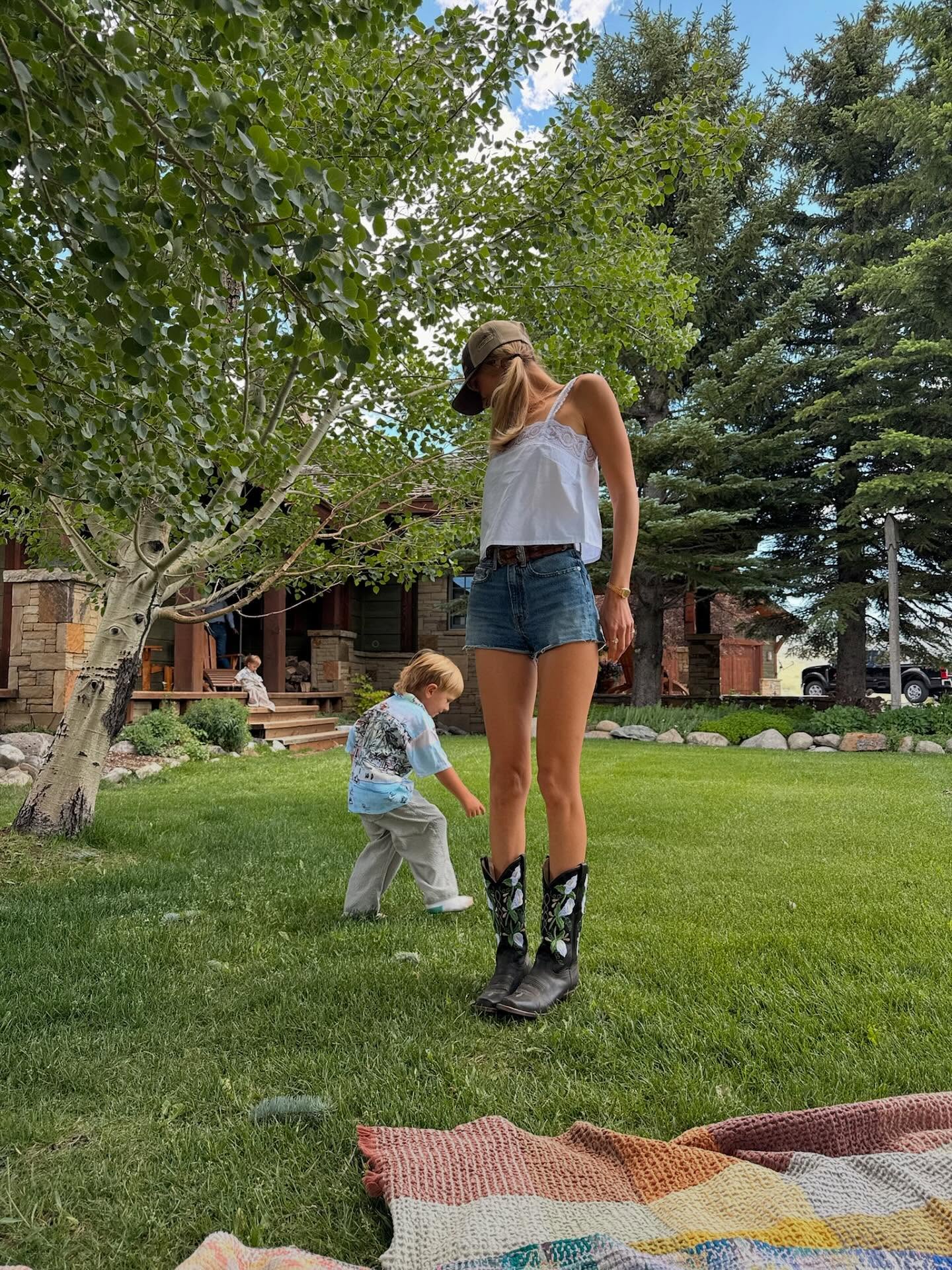 Bella Hadid wearing Frame The eyelet tank – White, Citizens of Humanity Marlow denim shorts – Medium wash and Welcome To Dannies Womans gray suede.