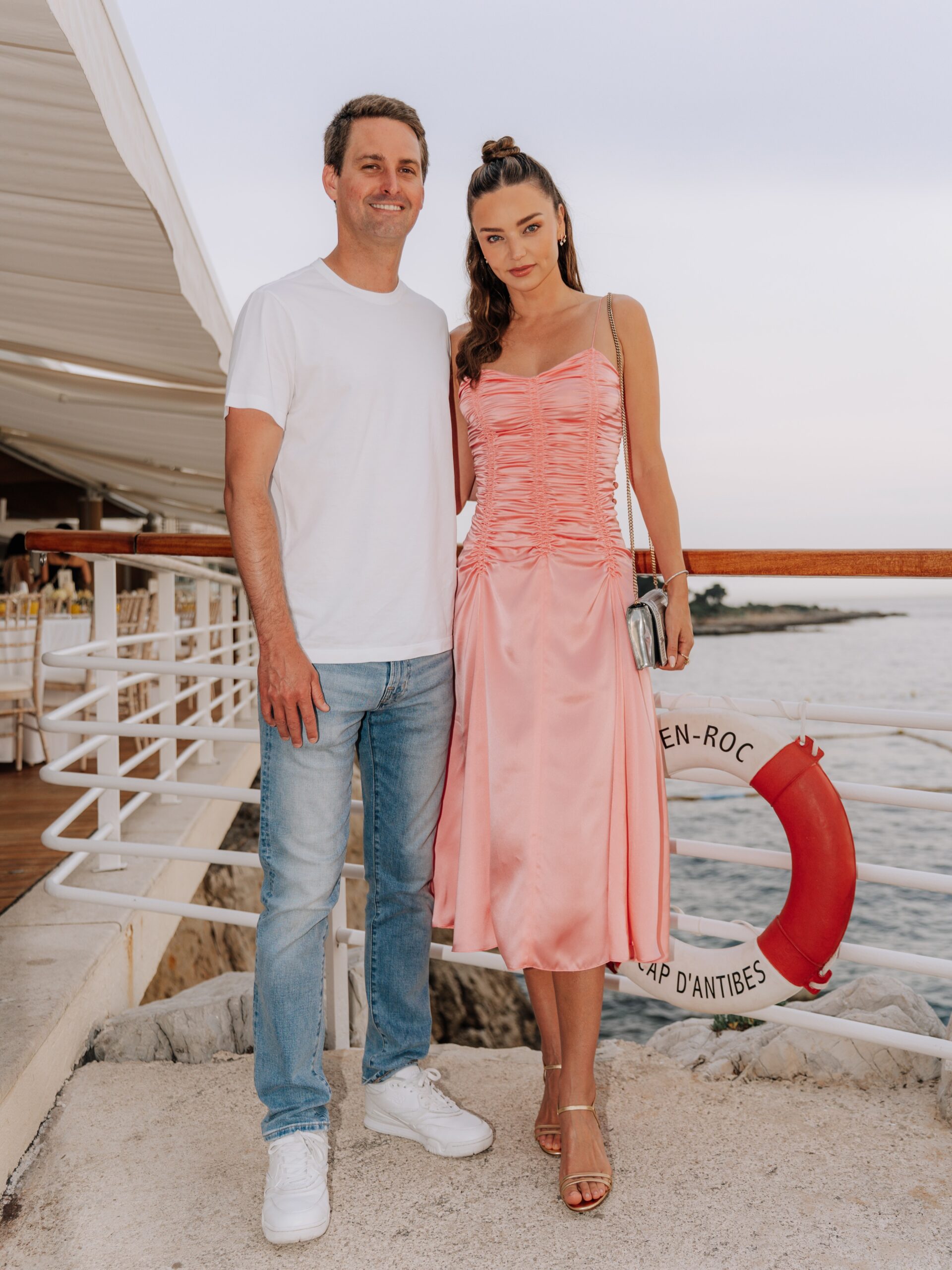 Miranda Kerr wearing Khaite Raina dress, Christian Louboutin Loubi54 metallic leather clutch – Grey and Manolo Blahnik Ciagalo metallic leather sandals.