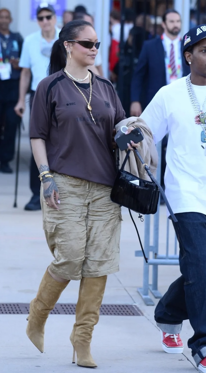 Rihanna wearing Vetements Trademark Football Jersey – Chocolate Brown, Aflalo Bromer crinkled-satin straight-leg shorts and Khaite River suede knee high.