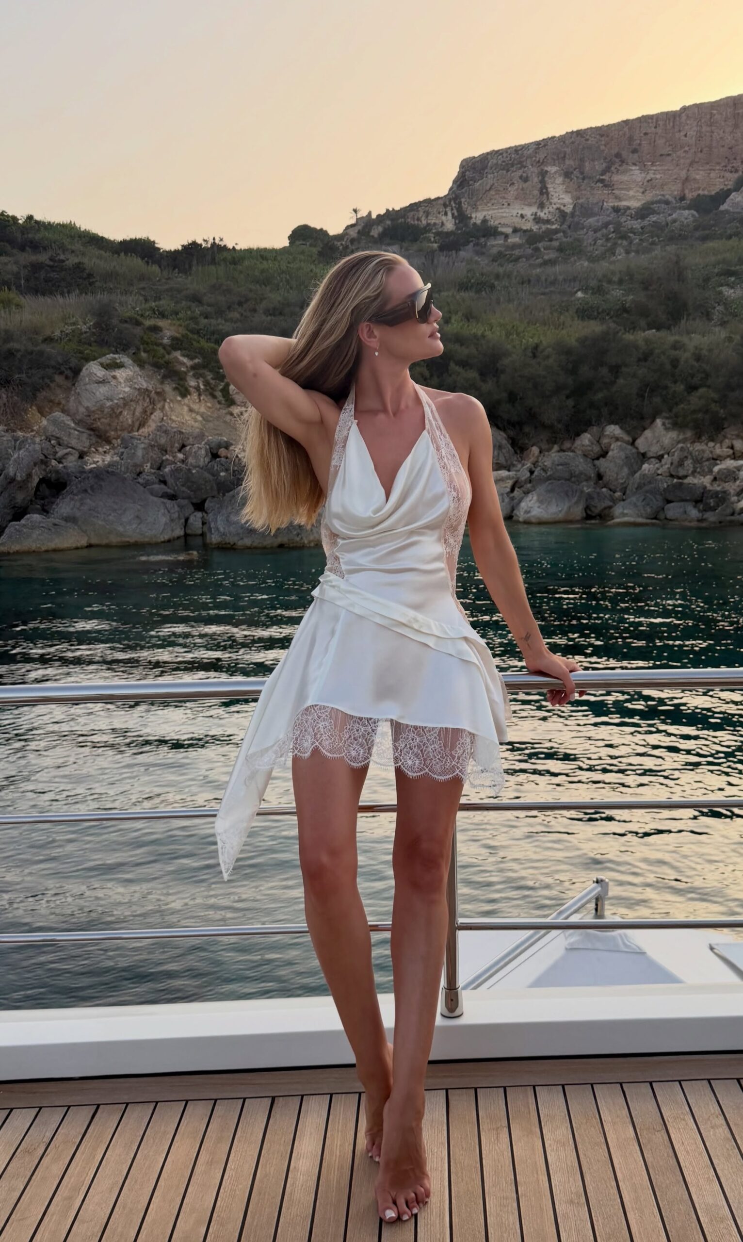 Rosie Huntington-Whiteley wearing Phoebe Philo Half bombe shield sunglasses and Revolve Gaspard Mini Dress – White.