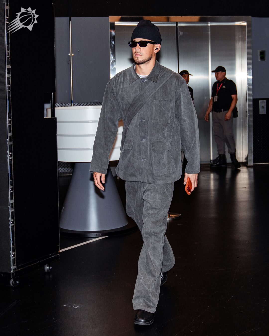 Devin Booker wearing Bottega Veneta Dizzy square sunglasses in black/grey, Professor.E Professor.E e work jacket in natural dyed grey jacket and Professor.E.