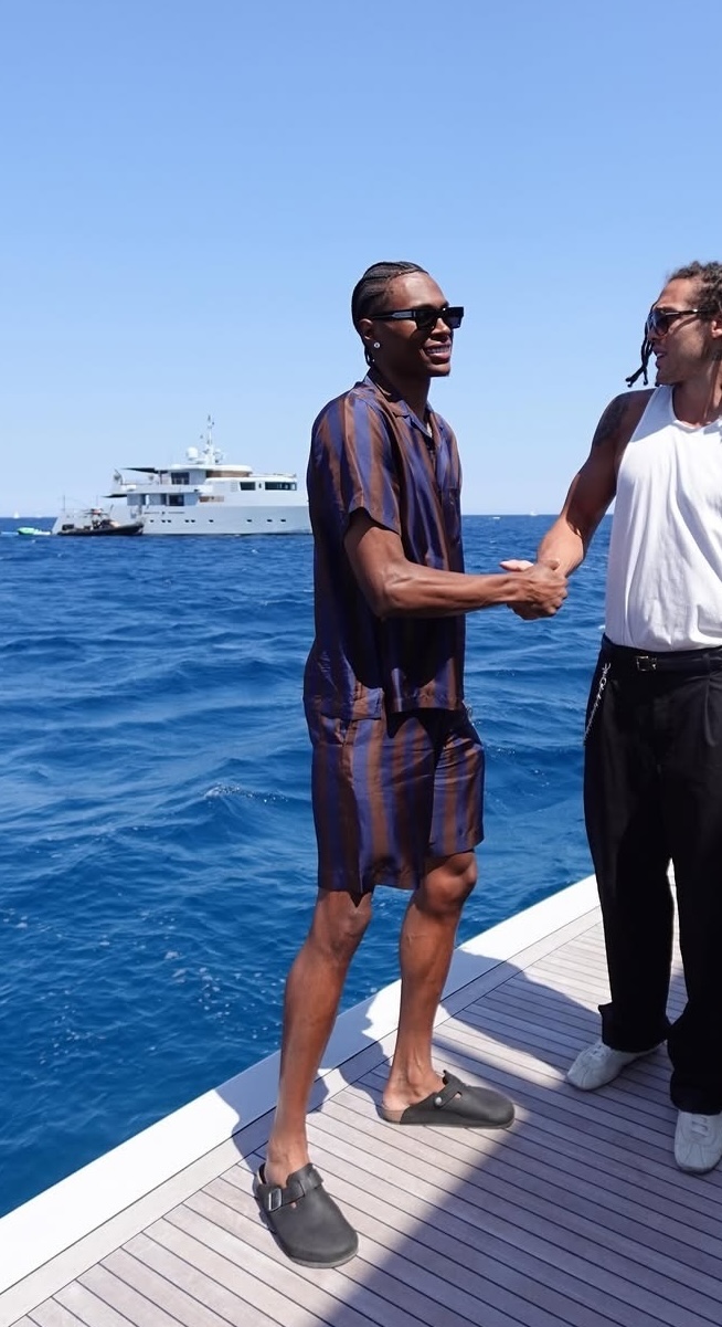 Peyton Watson wearing Fendi Short-sleeve silk shirt brown and blue, Fendi Striped silk shorts brown and blue and Birkenstock Boston natural leather oiled dark.