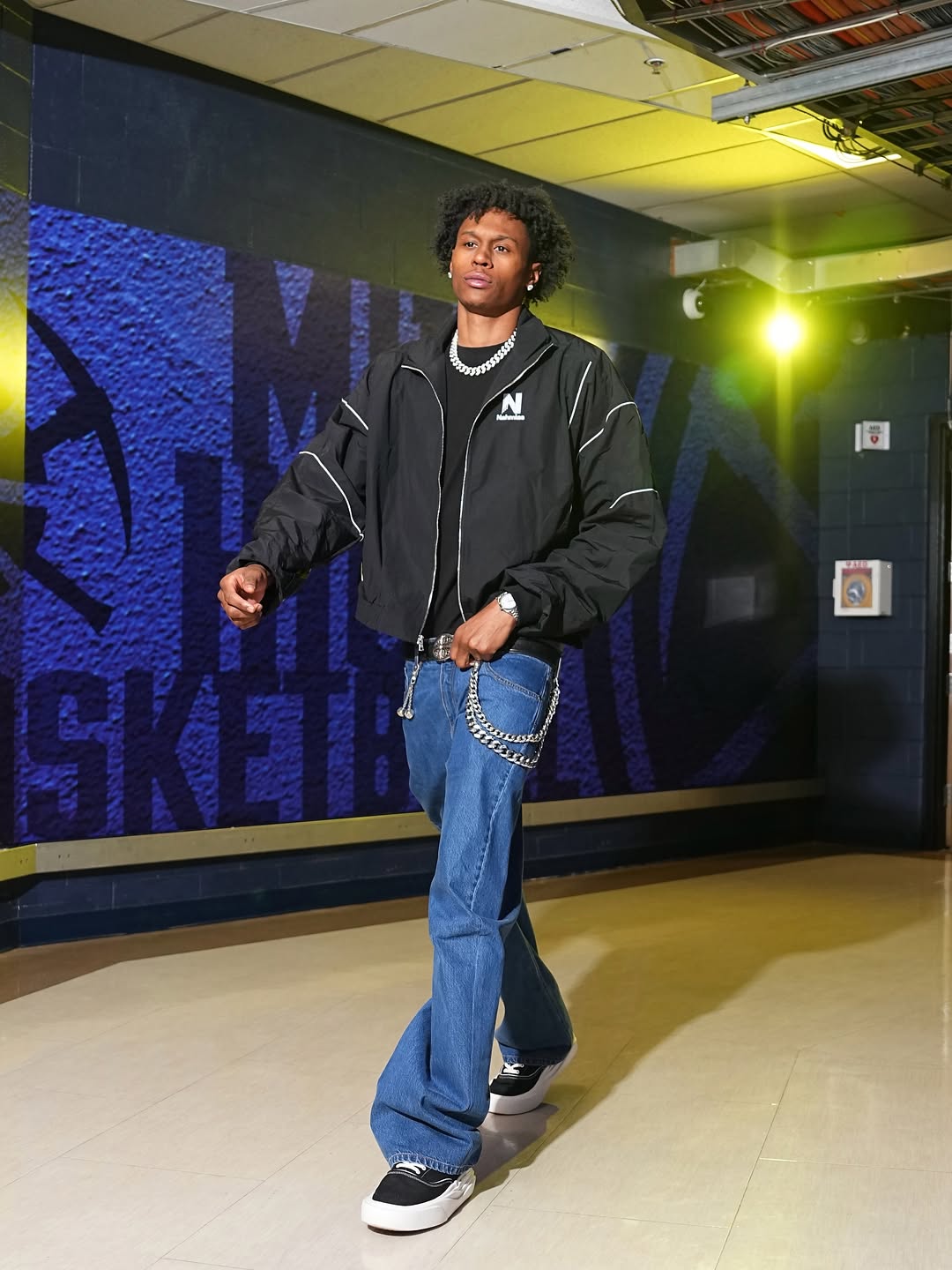 Peyton Watson wearing Nahmias Warm up jacket black, Nahmias Wide-leg jeans blue and Nahmias Ollie canvas sneaker in black.
