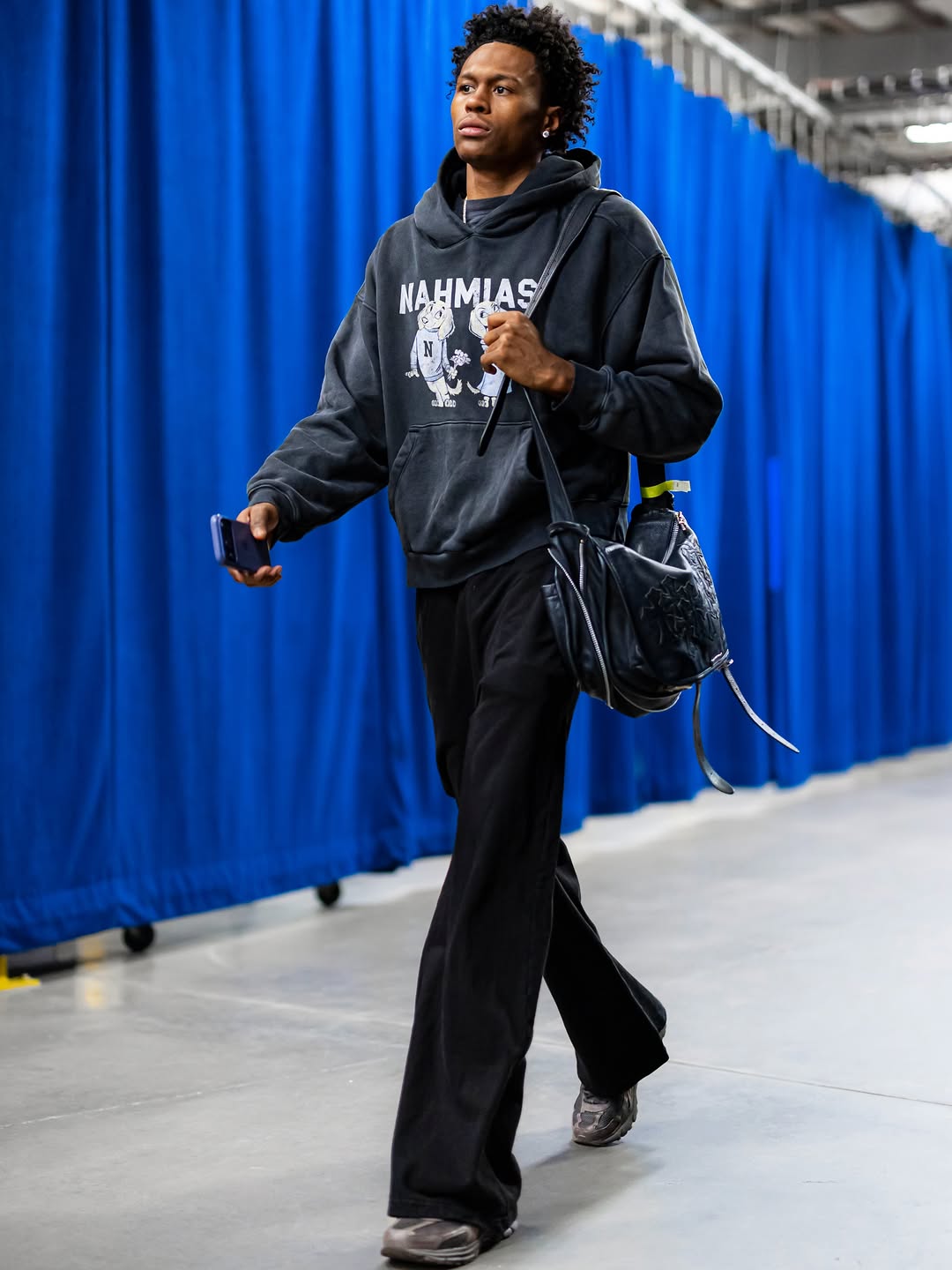 Peyton Watson wearing Nahmias Mascot Hoodie Worn Black, Hudson Jeans Walker coated kick flare jeans black and Balenciaga Runner Sneaker in matte black mesh.