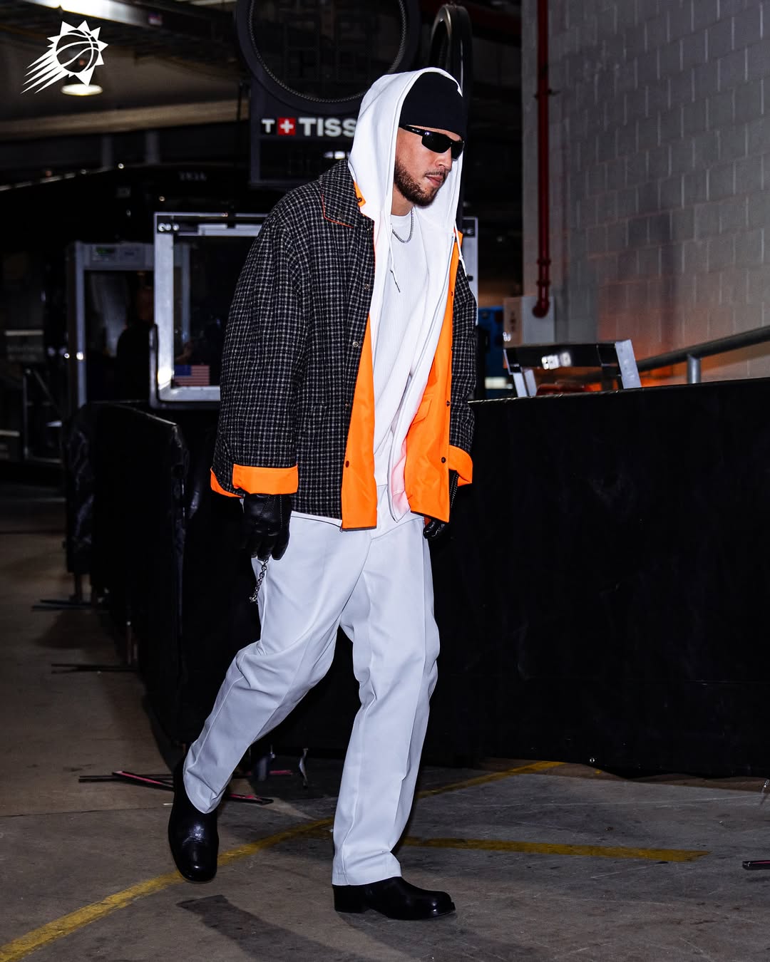 Devin Booker wearing Maison Margiela Reversible sports jacket Orange andchecker, Maison Margiela Wool tuxedo white trousers and Lemaire Zipped boots in Soft.