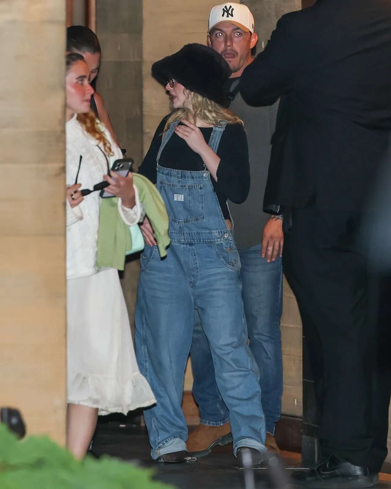 Sabrina Carpenter wearing Unreal Fur Yeoman bucket hat and Levi’s Full length wide leg overall light blue.