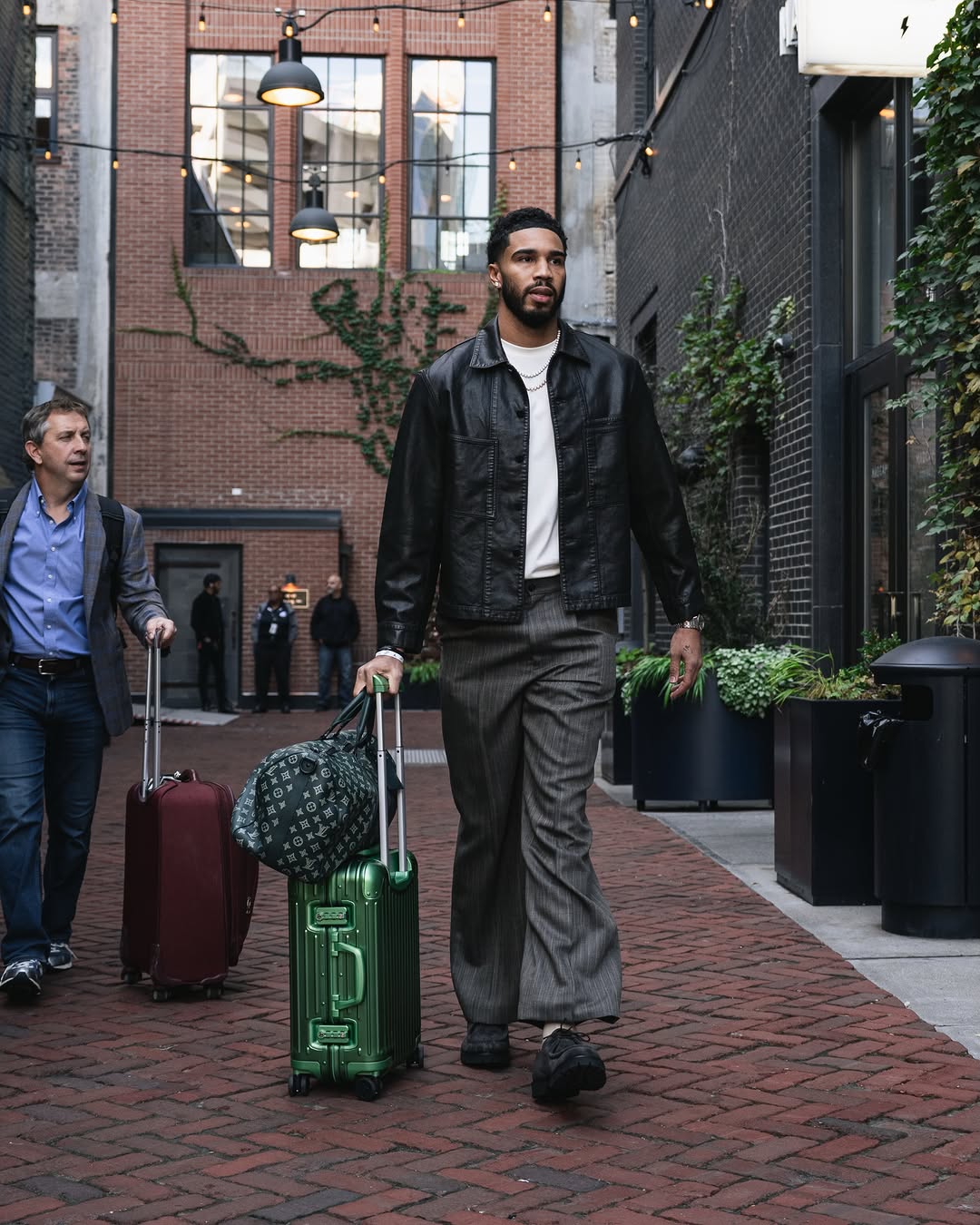 Jayson Tatum wearing Lemaire Workwear overshirt in coated denim black, Gucci Pinstripe wool pants grey and Barebound Neros barefoot lace-up shoe black.