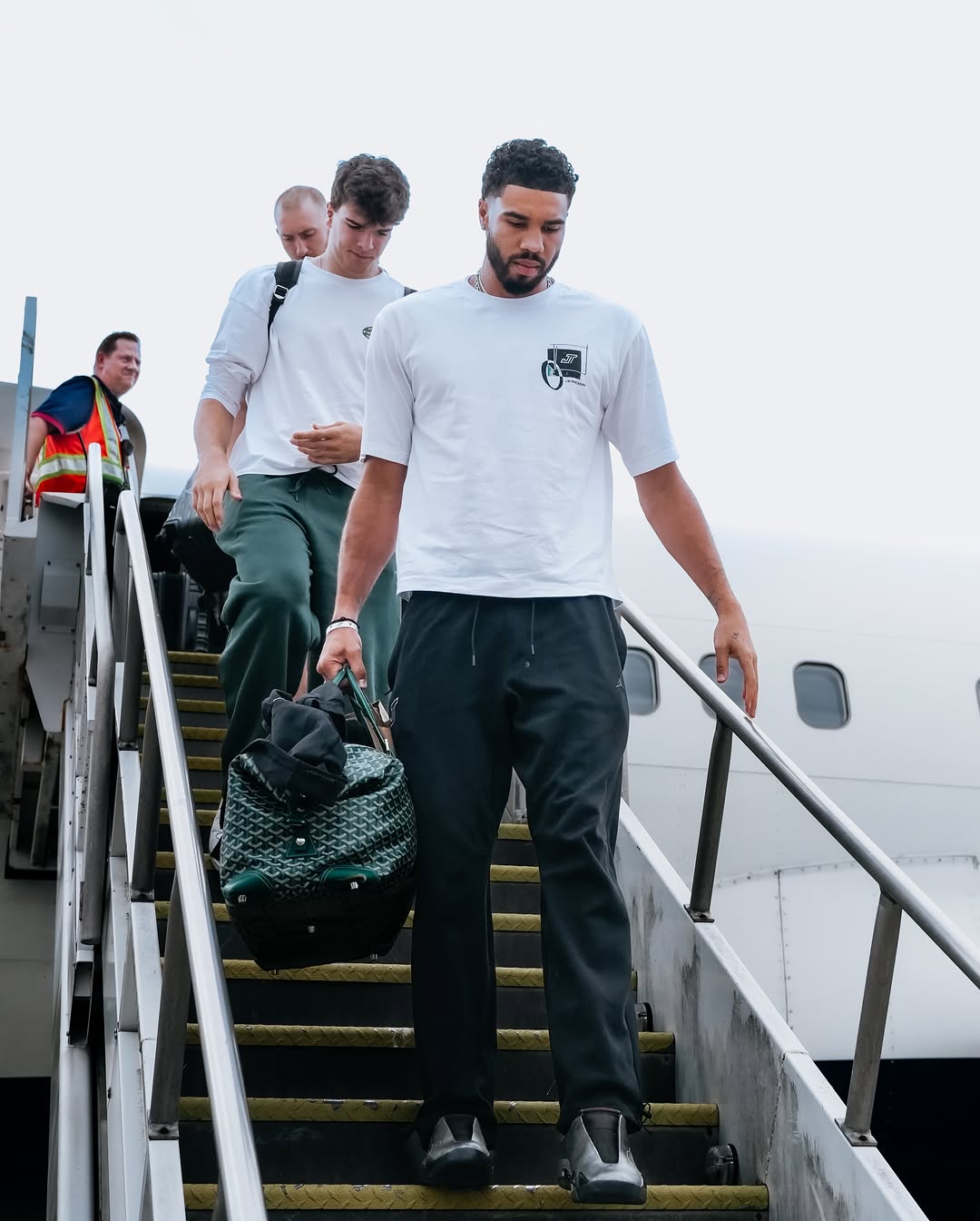 Jayson Tatum wearing Nike Tatum sport men’s dri-fit basketball t-shirt white, Nike Jordan brooklyn fleece men’s pants black and Air Jordan Air.