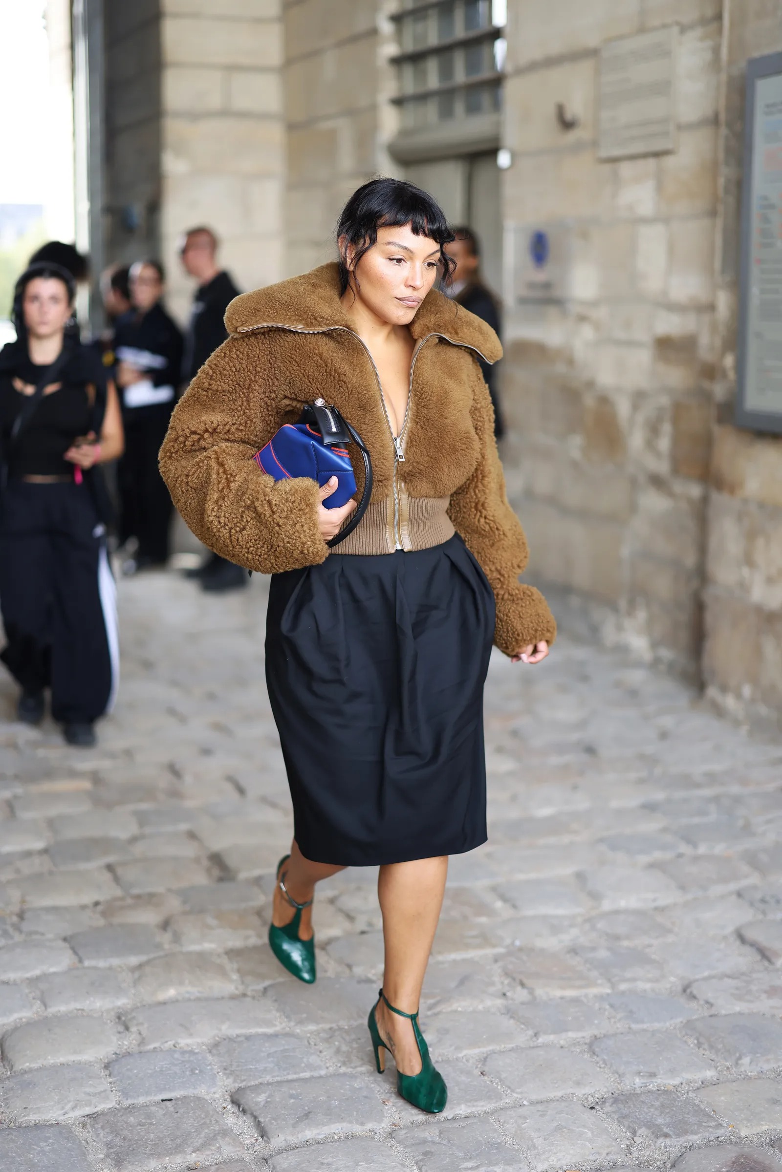 Paloma Elsesser wearing Helsa Faux fox bomber jacket beige brown, Prada Silk mini skirt midnight and Jimmy Choo Dark green leather faux python pumps.